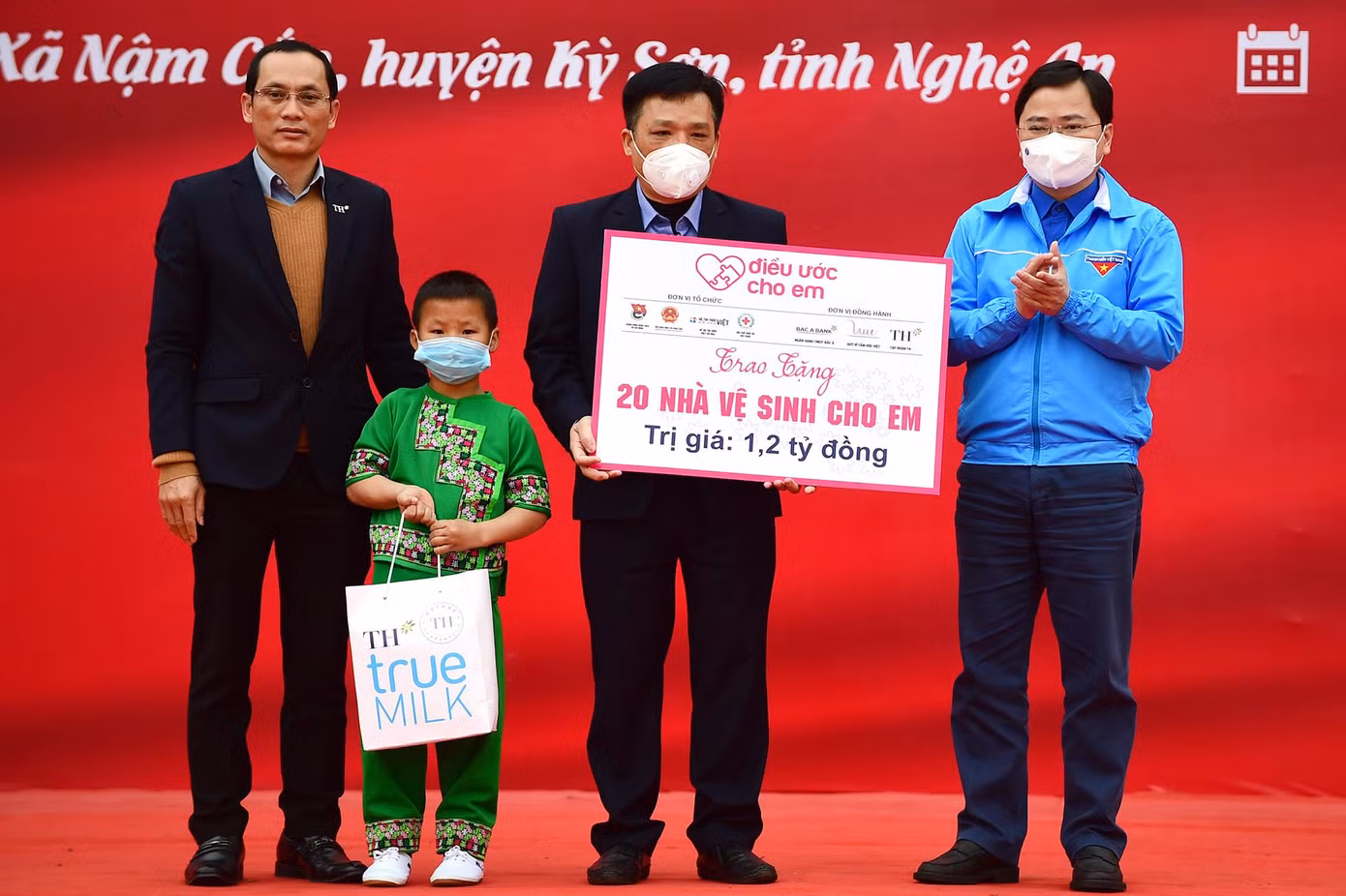 Anh Nguyễn Anh Tuấn và đại diện Tập đoàn TH True Milk trao biển 20 công trình Nhà vệ sinh cho em. Ảnh: Xuân Tùng