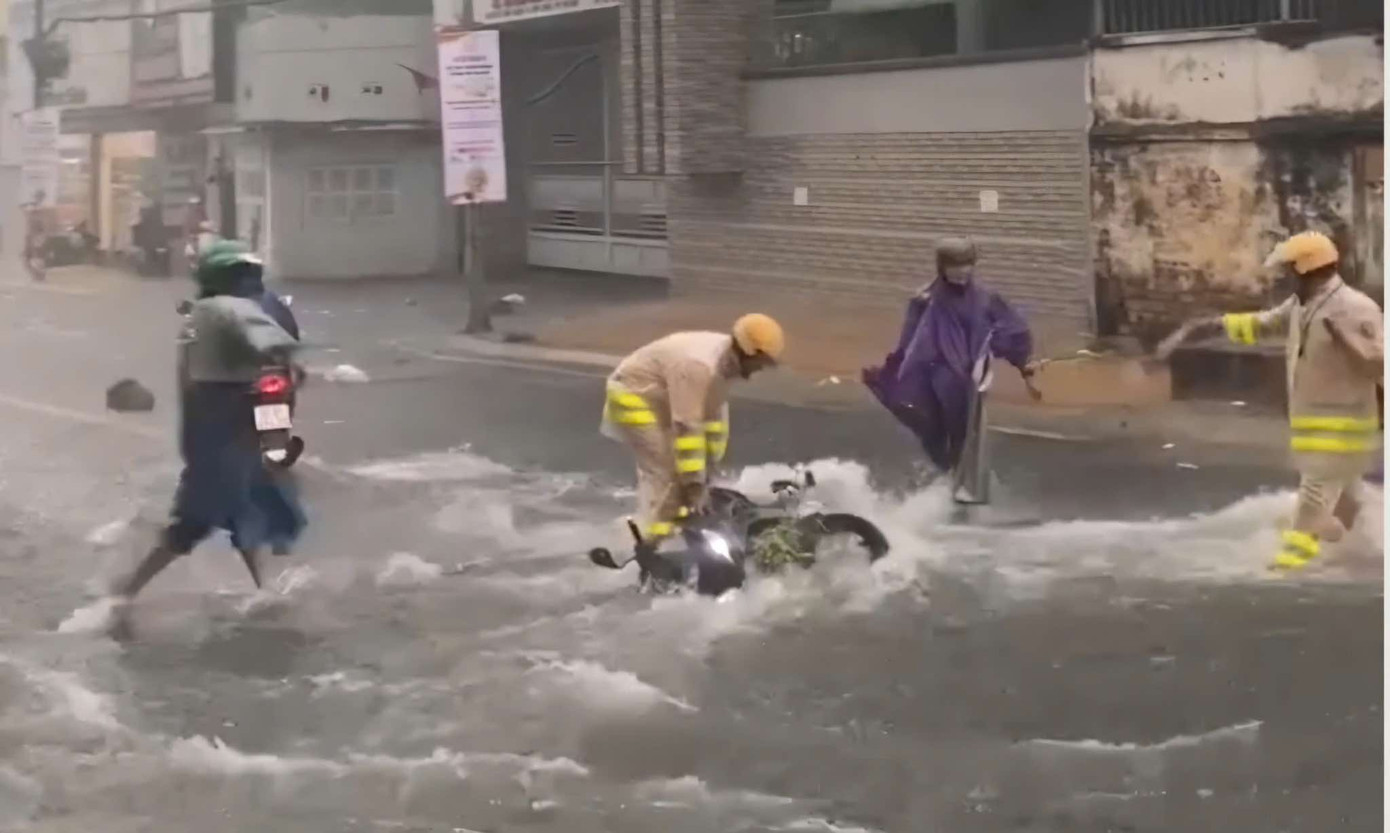 CSGT hỗ trợ người dân khi xe máy bị cuốn trôi trên đường Võ Văn Ngân (TP Thủ Đức)