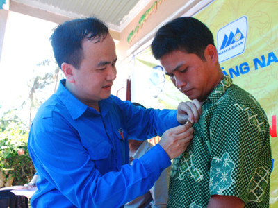 Anh Lò Quang Tú gắn Huy hiệu Tuổi trẻ dũng cảm cho anh Bùi Văn Phải. ảnh: Nguyễn Thành 