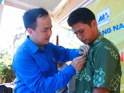 Anh Lò Quang Tú gắn Huy hiệu Tuổi trẻ dũng cảm cho anh Bùi Văn Phải. ảnh: Nguyễn Thành 
