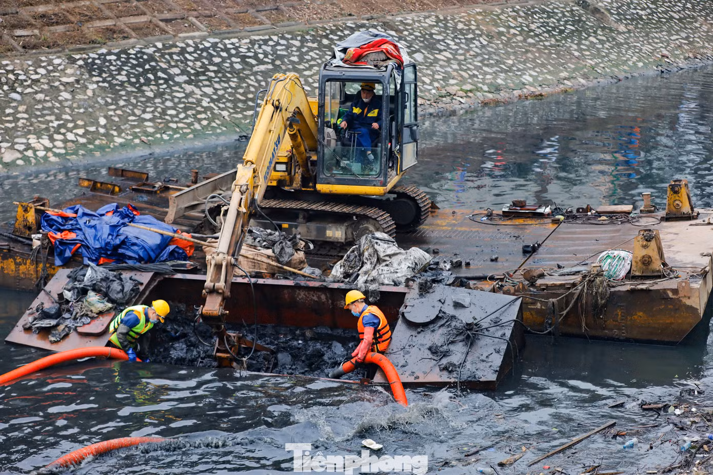 Những mảng bùn thải dày, đặc quánh, đen kịt, bốc mùi hôi thối liên tục được các công nhân cùng thiết bị chuyên dụng xe cẩu nạo vét lên từ đáy sông Tô Lịch.
