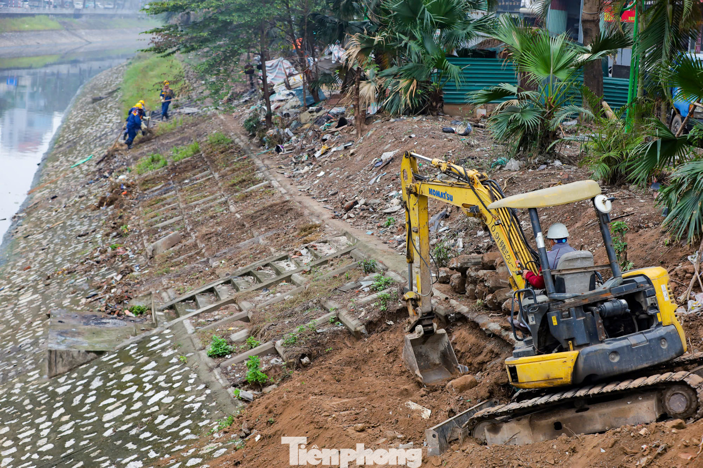 Phía trên bờ, công nhân điều chỉnh hệ thống đường ống dẫn bùn thải từ dưới lòng sông lên xe bồn.