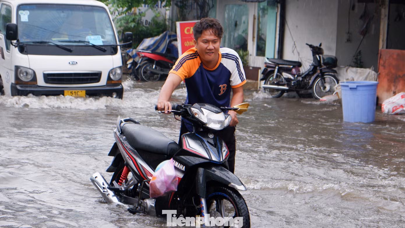 Người dân chật vật đi qua điểm ngập sâu.
