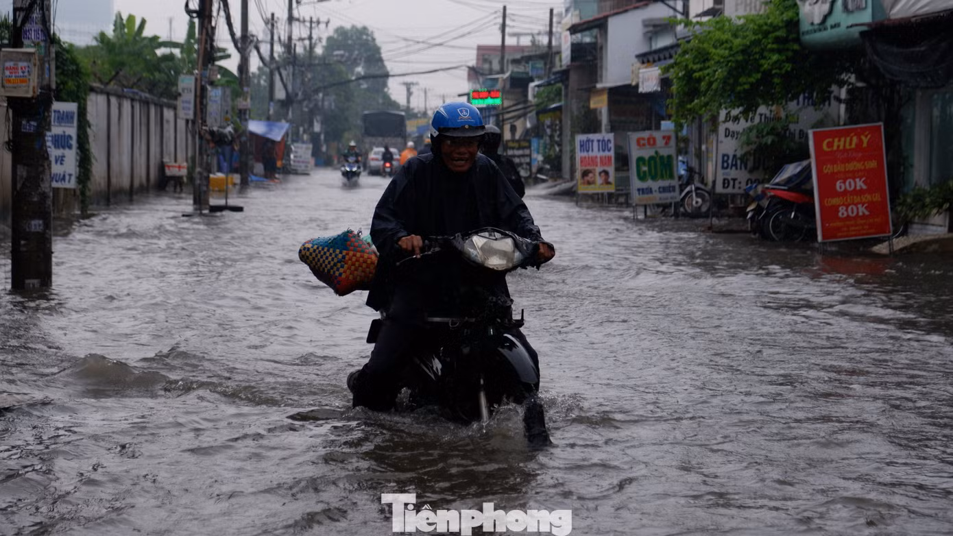 Người dân chật vật đi qua điểm ngập sâu.