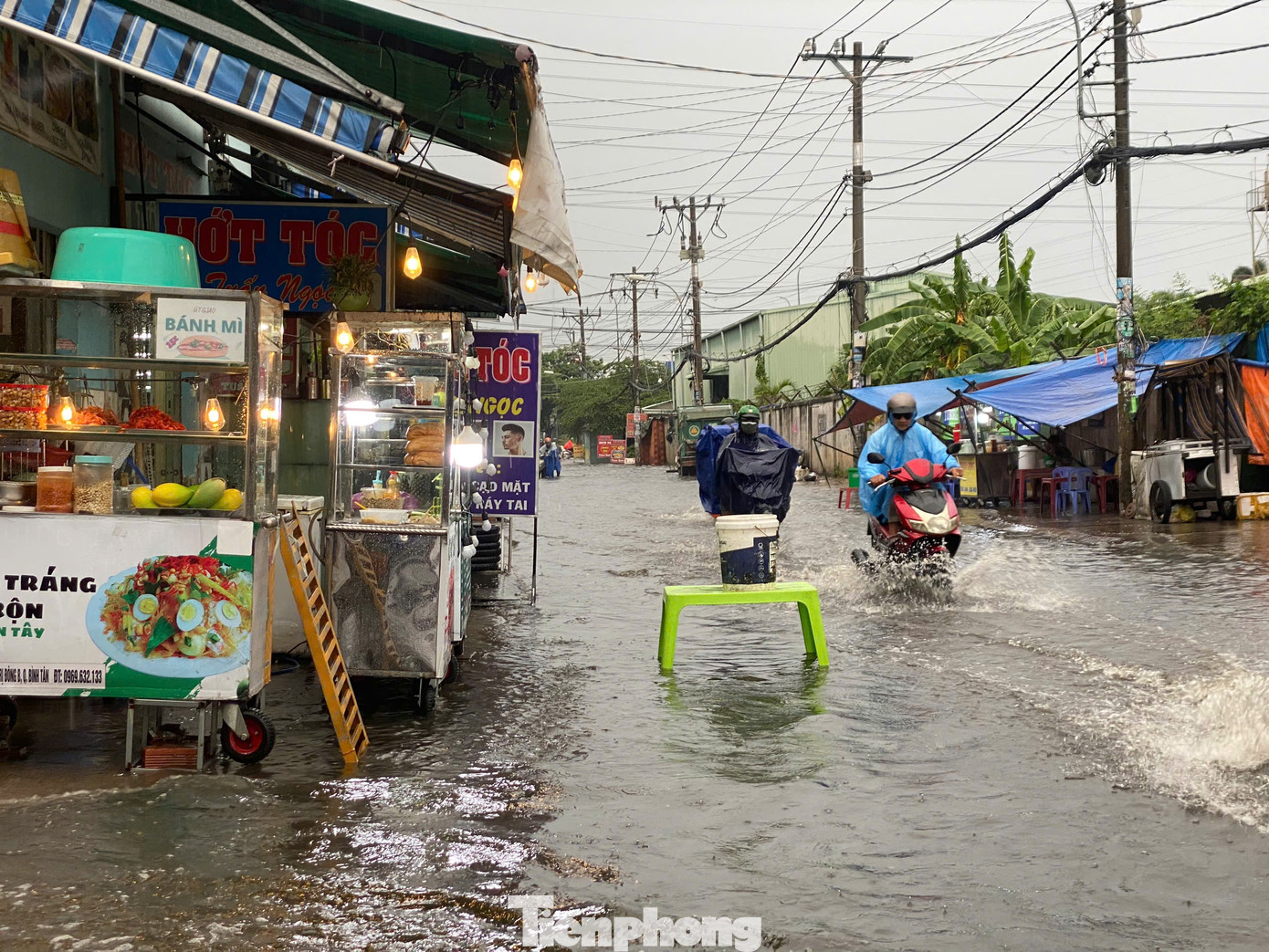 Một số hàng quán phải đặt bàn ghế ra ngoài đường để các phương tiện né tránh văng nước vào nơi kinh doanh.