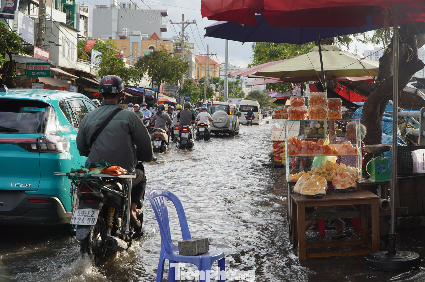Một số tiểu thương phải kê ghế nhựa để ngăn các phương tiện đi qua làm văng nước bẩn vào hàng hóa đang buôn bán.