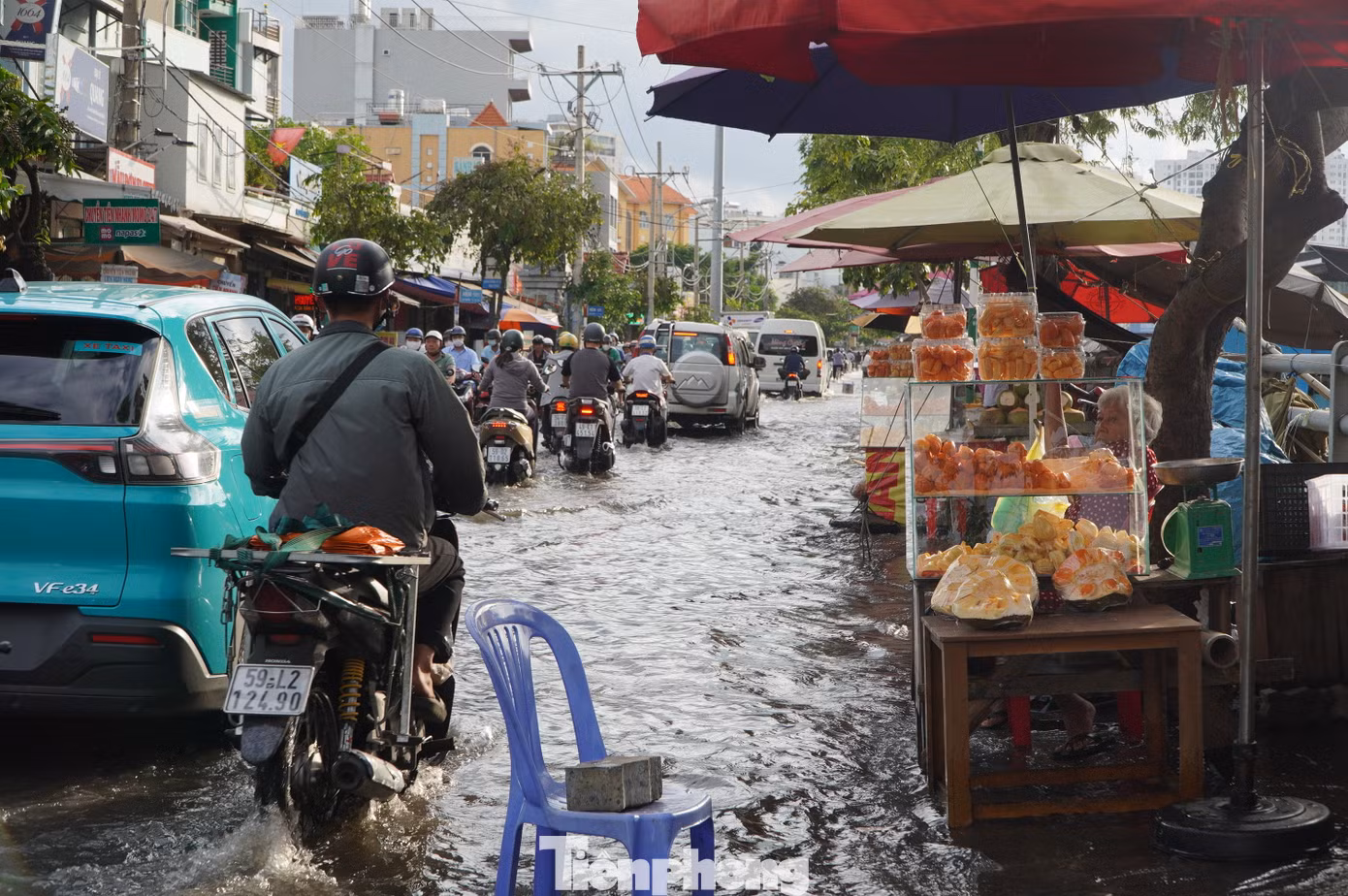 Một số tiểu thương phải kê ghế nhựa để ngăn các phương tiện đi qua làm văng nước bẩn vào hàng hóa đang buôn bán.