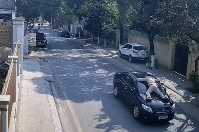 Ông Lâm điều khiển ô tô hất văng cảnh sát giao thông lên nắp ca pô (Ảnh: Cắt từ video).