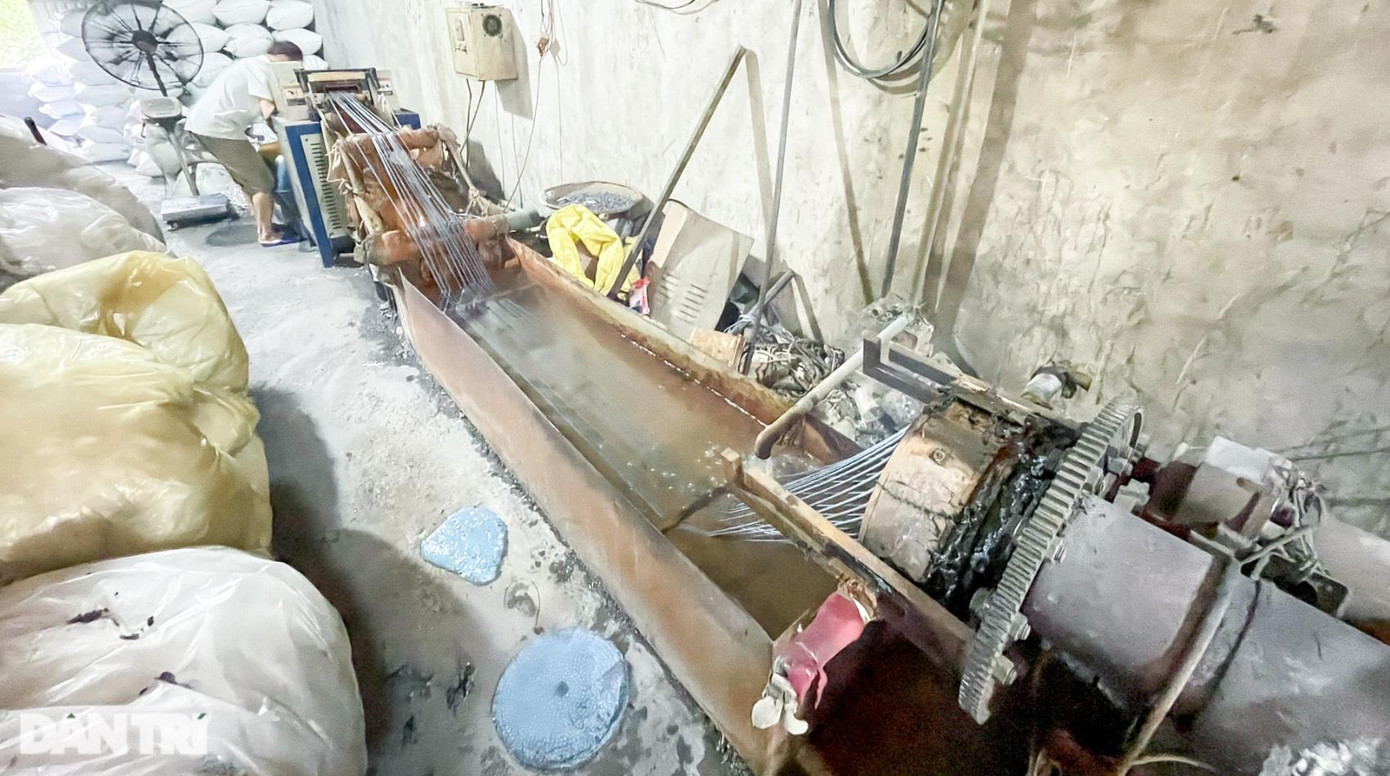 Nilon sau khi "giặt" nhanh sẽ được nung chảy, thợ quật dùng xẻng xúc khối nhựa cho vào máy để tạo hạt.