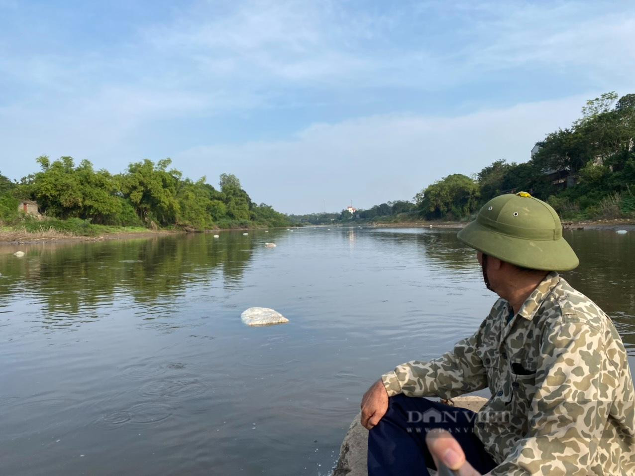 Những bao tải chứa xác gia súc, gia cầm chết nổi trên mặt sông Đáy. Ảnh: Văn Hoàng