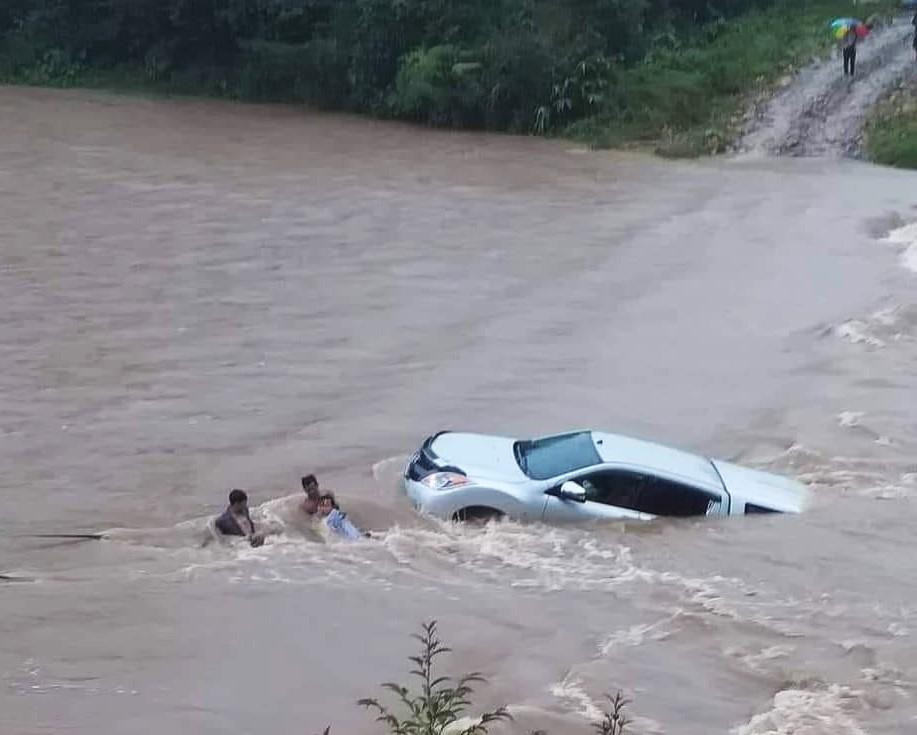 Người dân hỗ trợ giữ xe không bị cuốn theo dòng nước lũ. Ảnh: PN (Báo Kon Tum điện tử)