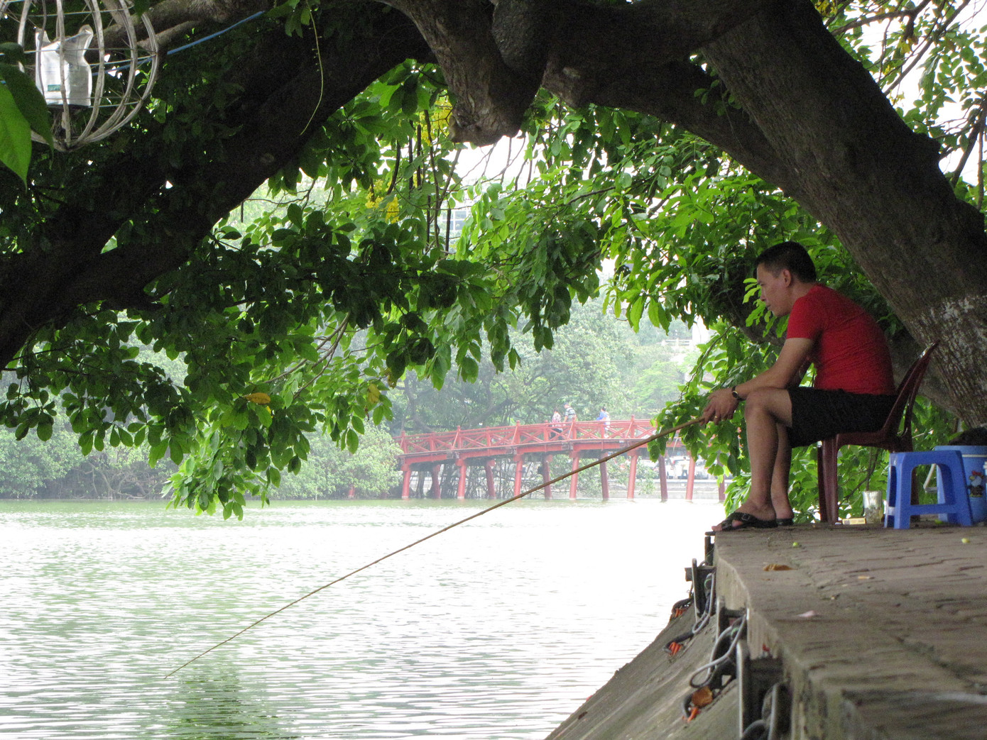 Ngồi ghế nhựa, uống trà đá thản nhiên câu cá ở Hồ Gươm. Ảnh: Trường Phong