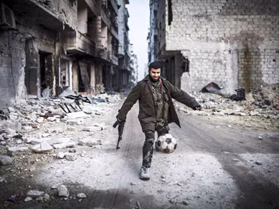 Một phiến quân Syria chơi bóng đá tại khu vực đang xảy ra giao tranh tại thủ đô Aleppo ngày 2/1. (Nguồn: AP)