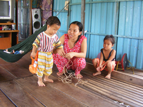 Chị Tuyết buộc con trước khi cùng chồng đi đánh cá