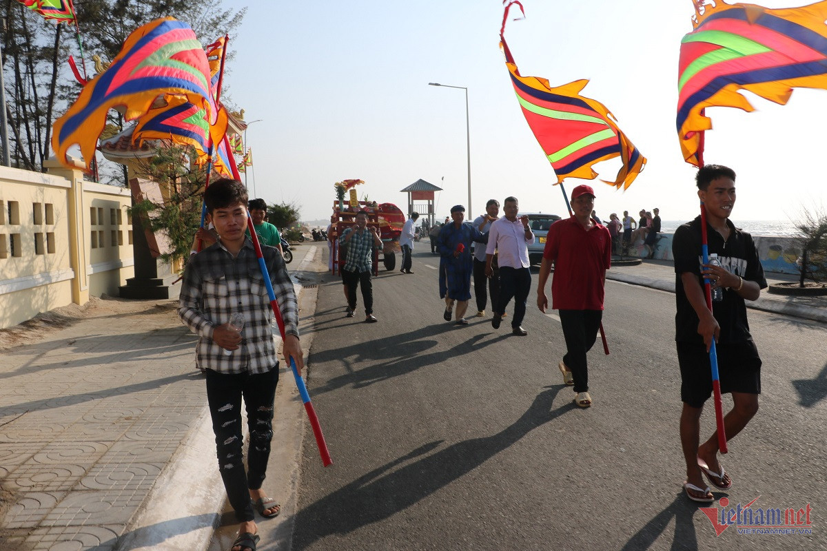 Đoàn rước gồm 15 người mang cờ ngũ sắc, đánh chiêng, trống đưa cốt cá Ông về Dinh để làm lễ cúng.