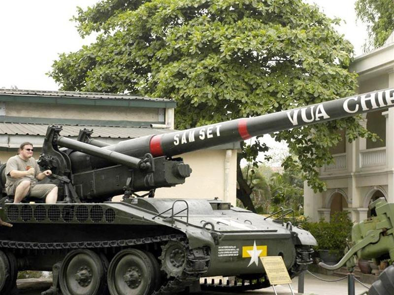 Một du khách phương Tây thích thú ngồi trên Pháo Tự hành 175cm (thường gọi là Vua chiến trường do ta thu được)