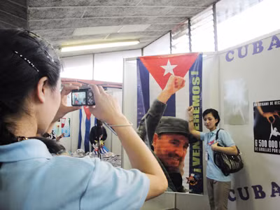 Chụp hình cho nhau bên ảnh Chủ tịch Fidel 