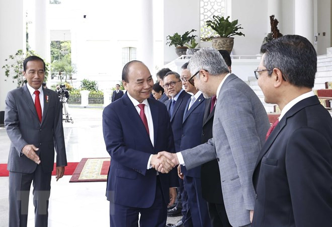 Tổng thống Joko Widodo giới thiệu các thành viên Đoàn đại biểu Indonesia với Chủ tịch nước Nguyễn Xuân Phúc. (Ảnh: Thống Nhất/TTXVN).