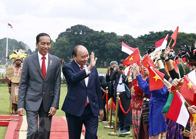 Chủ tịch nước Nguyễn Xuân Phúc và Tổng thống nước Cộng hòa Indonesia Joko Widodo tại lễ đón. (Ảnh: Thống Nhất/TTXVN).