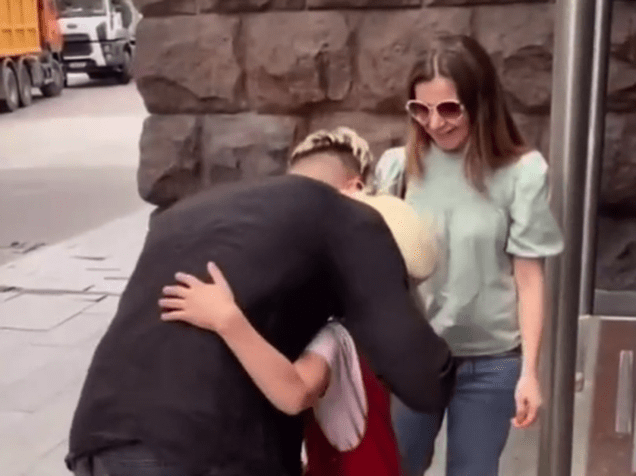 Sau khi được tặng chiếc điện thoại, cô bé mừng rỡ ôm lấy Voloshin mà không hề hay biết mình vừa bị lừa. Ảnh: TikTok