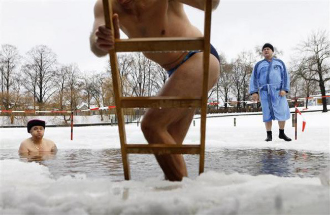 Với niềm tin việc tắm năm mới sẽ mang lại những điều an lành, các thành viên của câu lạc bộ bơi lội Seehunde Berliner bất chấp giá lạnh, bắt đầu năm mới với một bồn tắm trong băng ở hồ Oranke, Berlin.