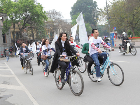 Hoa hậu Dương Thùy Linh (áo đen) tham gia đạp xe cùng các bạn trẻ để cổ động cho Giờ trái đất 2012