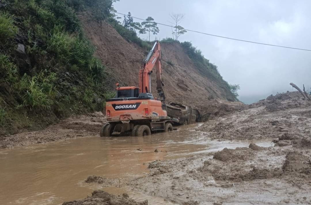 Lực lượng chức năng tiến hành cứu hộ và nạo vét đất đá trên đường.