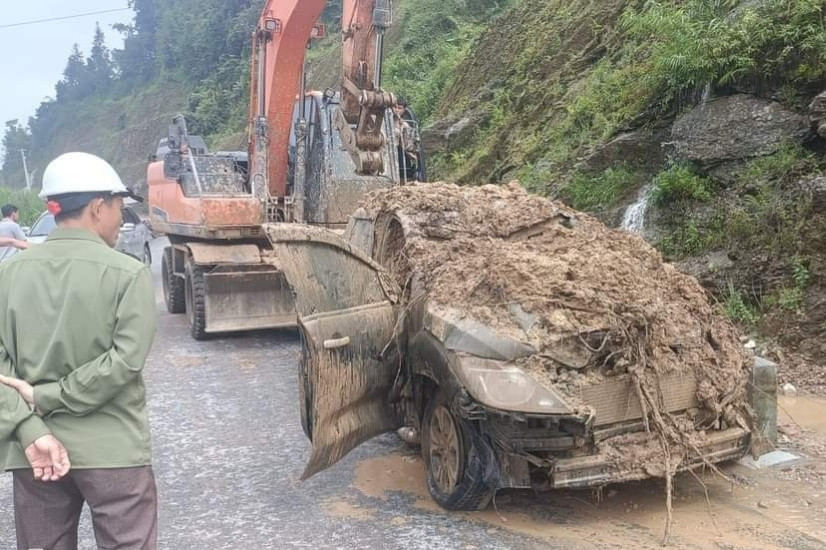 Chiếc ô tô bị vùi lấp được lực lượng chức năng cứu hộ ra khỏi khu vực sạt lở.