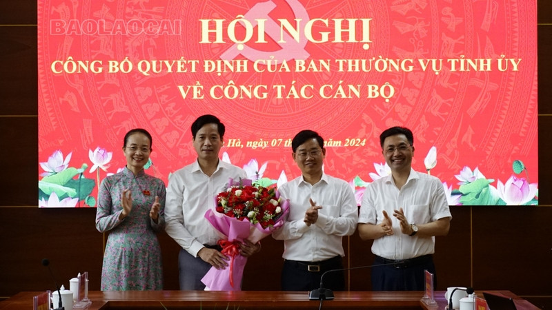 Ban Thường vụ Tỉnh ủy Lào Cai trao quyết định và tặng hoa ông Trần Xuân Thảo. Ảnh: Lê Hiếu.
