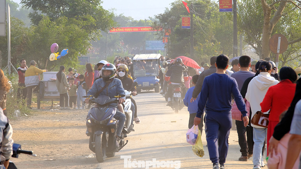 Nhiều du khách đi xe ô tô gửi ở bãi xe cách cổng khoảng 500m không đợi chờ được xe điện đã chọn cách đi bộ để kịp lên xe trở về chuẩn bị cho một năm mới lao động và học tập.