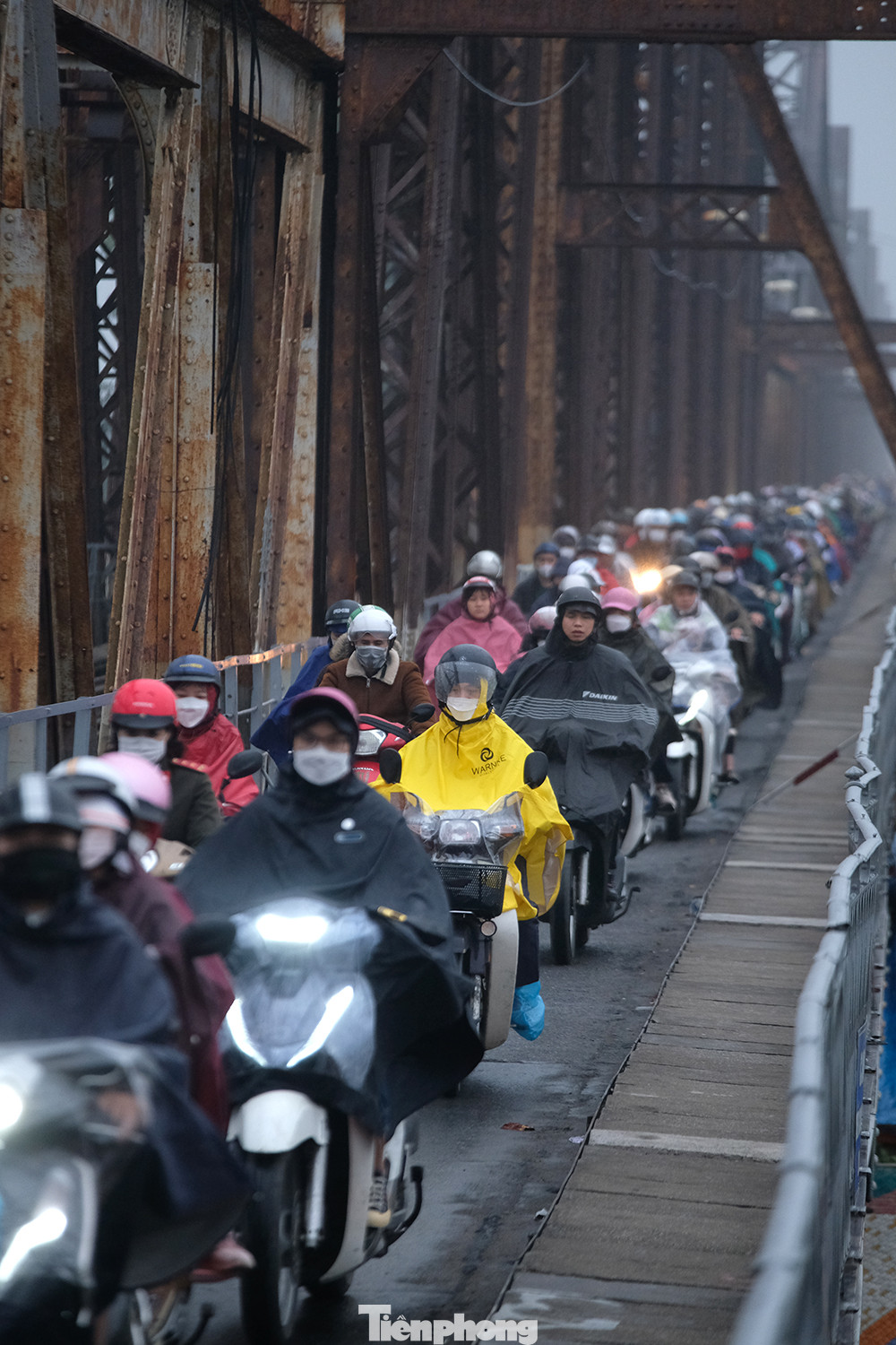 Dù chỉ mưa phùn nhẹ kèm nồm ẩm, nhưng người tham gia giao thông vẫn phải lụp xụp trong áo mưa tránh gió và nước bắn bẩn từ mặt đường.