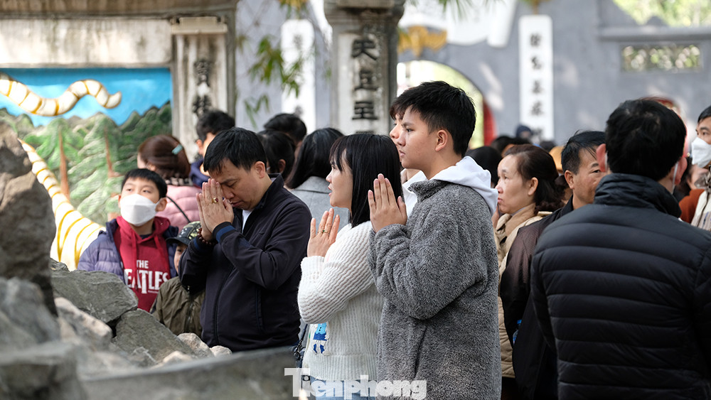 Các bạn trẻ làm lễ tại chân Tháp Bút bên Hồ Hoàn Kiếm, phía trước cổng Đền Ngọc Sơn.