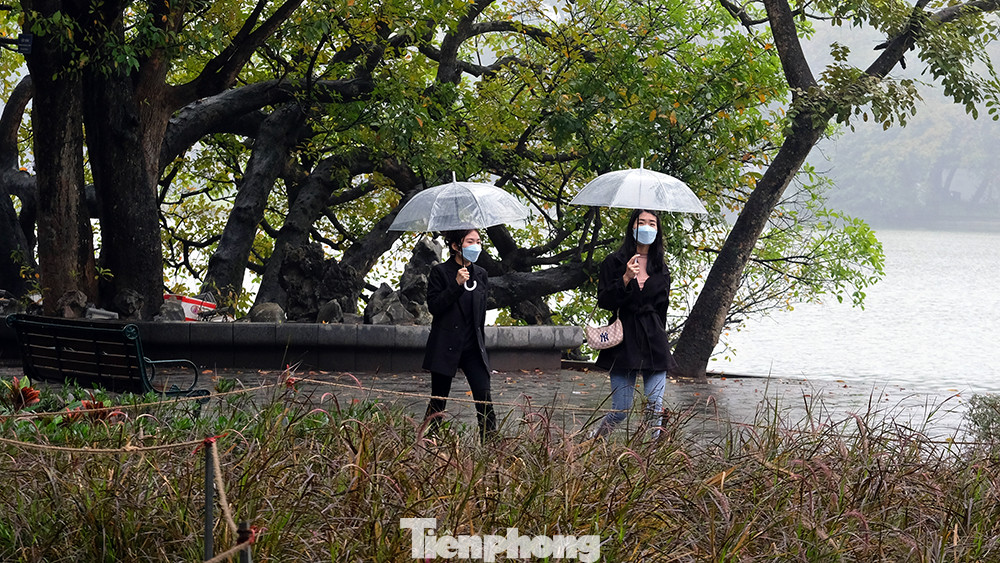 Du khách tản bộ ven hồ để cảm nhận vẻ đẹp rất riêng của Hà Nội giữa tiết trời mùa xuân.