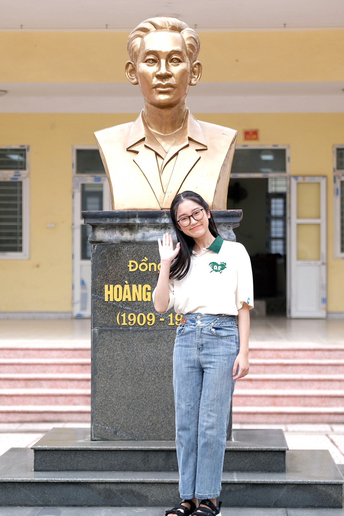 Vũ Thị Vân Anh tạo dáng bên bức tượng Hoàng Văn Thụ tại trung tâm khuôn viên ngôi trường dày dạn thành tích trong những năm gần đây của tỉnh Nam Định.