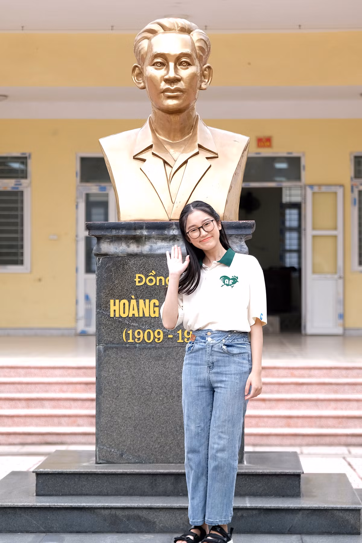Vũ Thị Vân Anh tạo dáng bên bức tượng Hoàng Văn Thụ tại trung tâm khuôn viên ngôi trường dày dạn thành tích trong những năm gần đây của tỉnh Nam Định.
