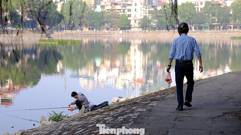 Người thả cá phóng sinh, người câu cá. Một cảnh tượng được coi là "éo le" thường thấy vào ngày này hàng năm.