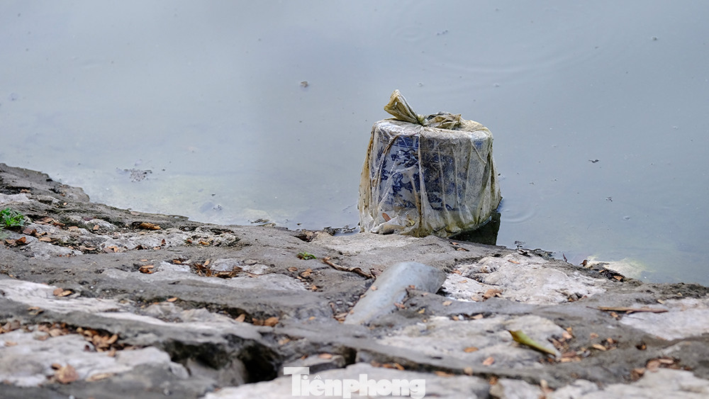 Bát hương cũng bị vứt bỏ bên mép nước hồ.