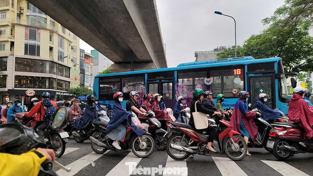 Đến thời điểm 9 giờ sáng nay (15/4), dù trời đã ngớt mưa nhưng nhiều người tham gia giao thông bằng xe máy vẫn mặc áo mưa trên đường để tránh gió rét.