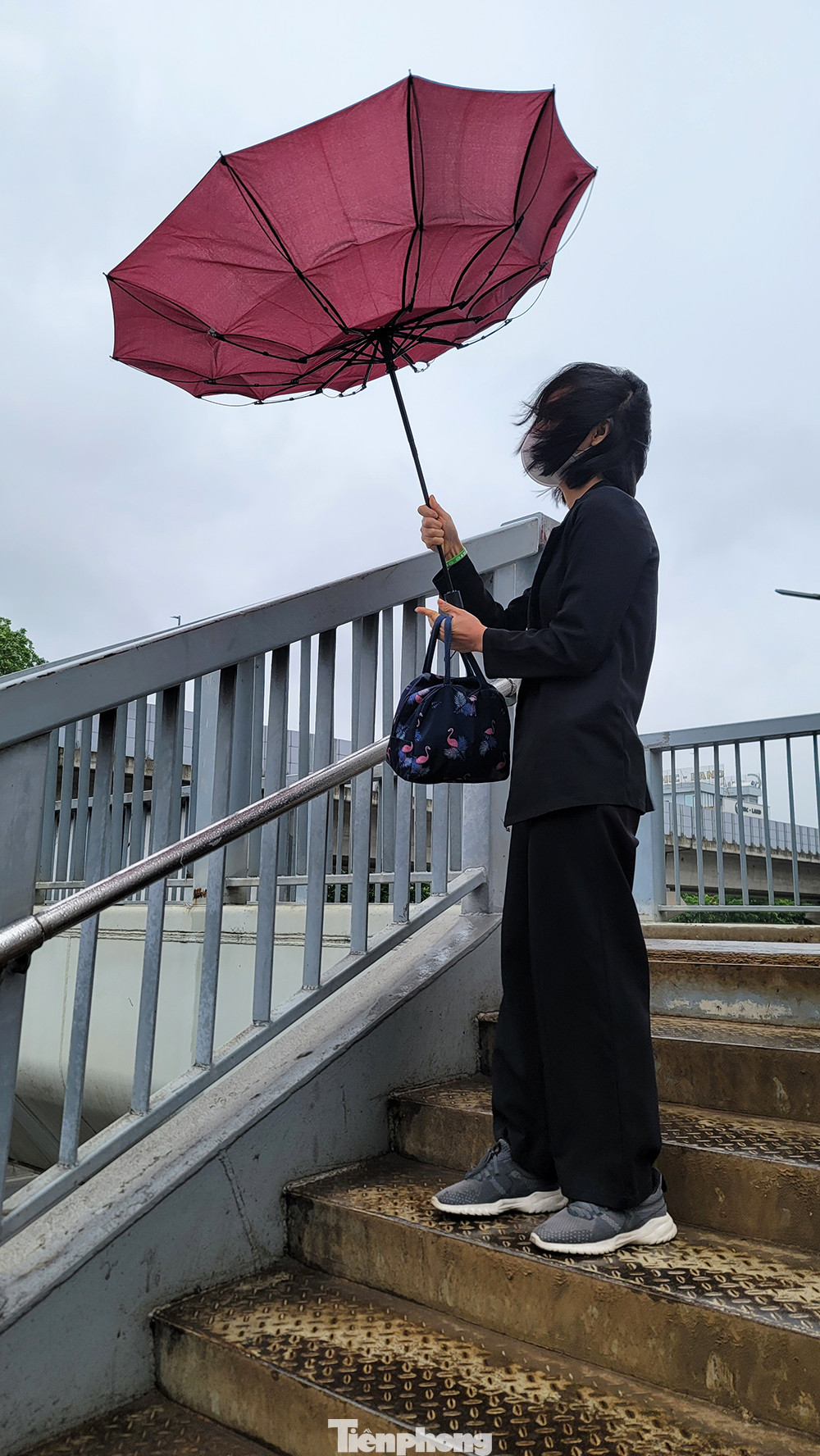 Mưa nhỏ kèm gió khá mạnh khiến người dân Thủ đô chật vật đến công sở trong thời tiết se lạnh.