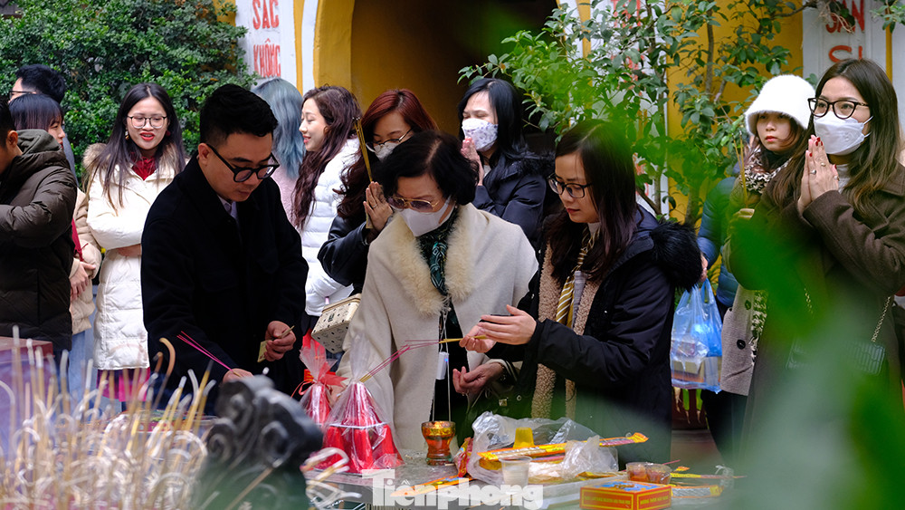 Phía ngoài sân, khu vực sắp lễ cũng khá đông đúc. Mọi người phải xếp hàng chờ đến lượt châm hương, chuẩn bị đồ lễ.