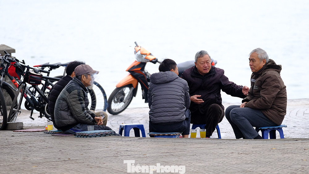 Các cụ cao tuổi tập thể dục buổi sáng ngồi co ro bên Hồ Tây uống cốc trà nóng, ngồi nói chuyện.