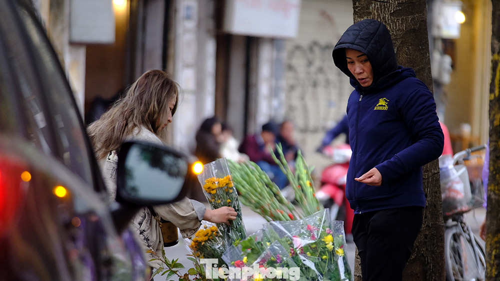 Trước cổng đền Quán Thánh, nhiều người tranh thủ mua hoa tươi đi lễ ngày đầu tiên đi làm trong năm mới.