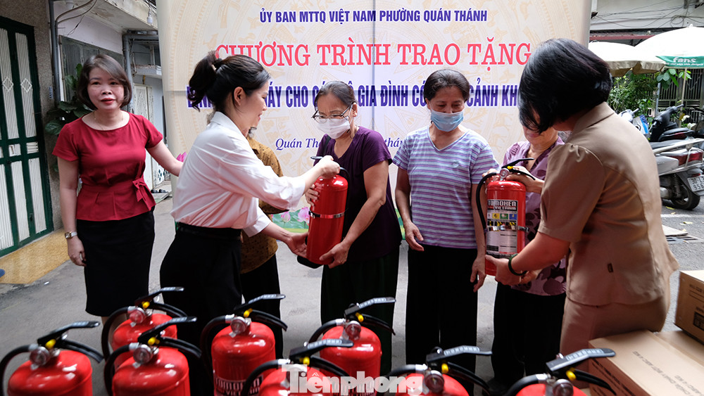 Đại diện phường Quán Thánh trao tặng bình chữa cháy cho cư dân trên địa bàn.
