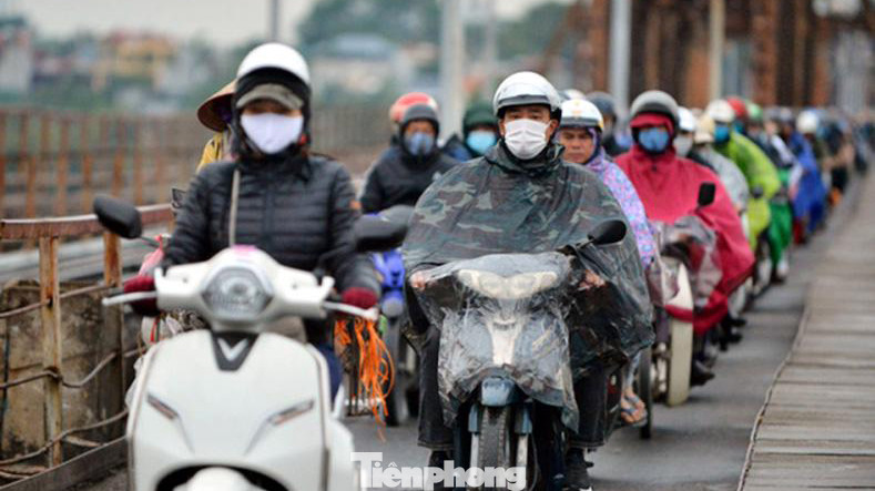 "Đi lại thời tiết như thế này không mặc áo mưa thì xe máy đi trước bắn nước bẩn từ mặt đường lên người, mặc vào thì khó chịu và vướng víu vì mưa chưa đủ ướt quần áo". Chị Phạm Linh vừa đi từ quận Long Biên sang khu vực trung tâm Hà Nội làm việc chia sẻ.