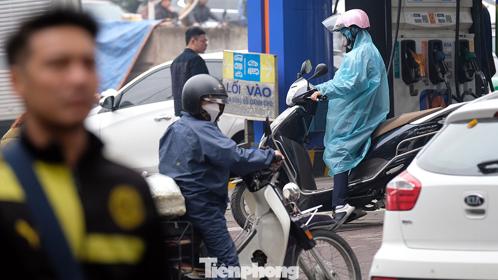 Đến gần trưa, nhiều người đi xe máy vẫn mặc áo mưa dù trời không... mưa.