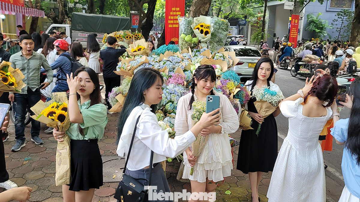 Các bạn trẻ chen chân check-in bên những xe hoa rực rỡ sắc Thu Hà Nội. Các bạn trẻ chen chân check-in bên những xe hoa rực rỡ sắc Thu Hà Nội.
