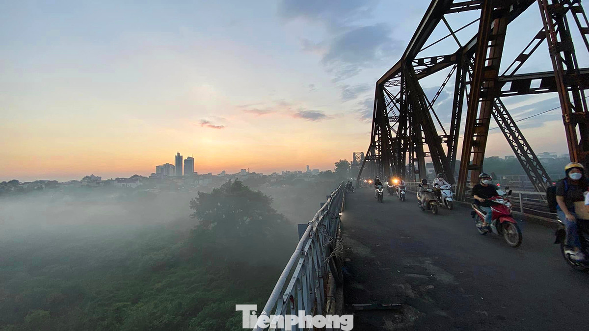 Sương khói là là dưới mặt đất khiến cây cầu Long Biên hơn trăm năm tuổi nổi bật trong khung cảnh thơ mộng khi hoàng hôn buông xuống.