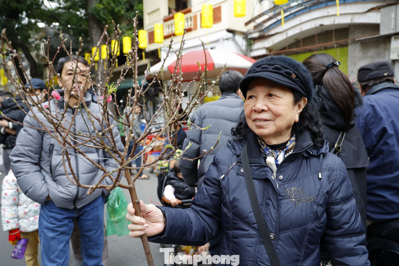 "Tôi chỉ mua cành nhỏ này về cho có không khí, mục đích chính chiều này là đi bộ để ngắm phố, ngắm hoa" - bà Hoa nhà ở phố Hàng Buồm (Hoàn Kiếm) vui vẻ chia sẻ.