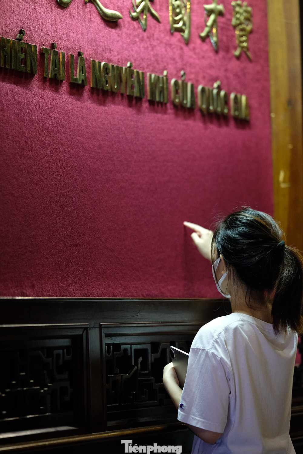 Một số bạn dùng ngón tay đưa nhẹ lên lớp vải nhung, nơi có dòng chữ 'Hiền tài là nguyên khí quốc gia' để mong xin được sự may mắn.