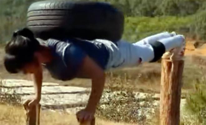 Cô ấy thực hiện bài tập bụng bằng cách treo người với tư thế chống đẩy trên 4 cọc gỗ với tạ là lốp xe trên lưng. Cô ấy thực hiện bài tập bụng bằng cách treo người với tư thế chống đẩy trên 4 cọc gỗ với tạ là lốp xe trên lưng.